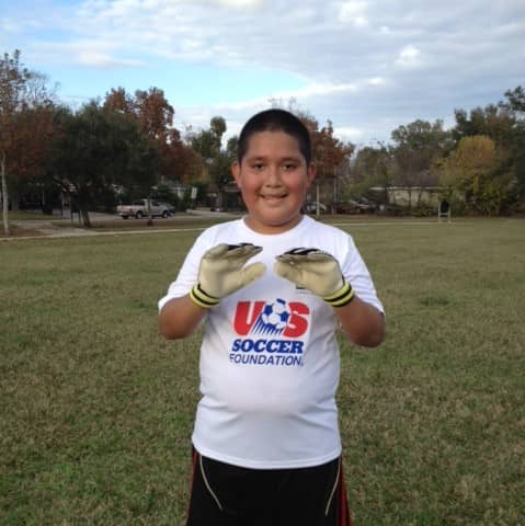 Juan smiling with soccer gloves